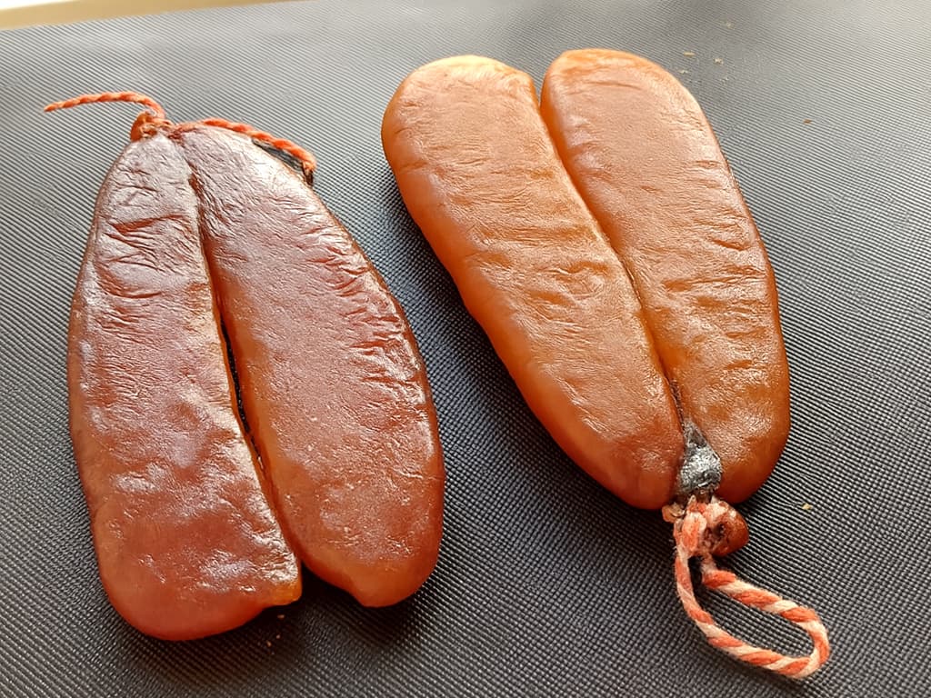左邊是野生烏魚子（形狀較修長、顏色不均），右邊是養殖烏魚子（圓潤、顏色一致）