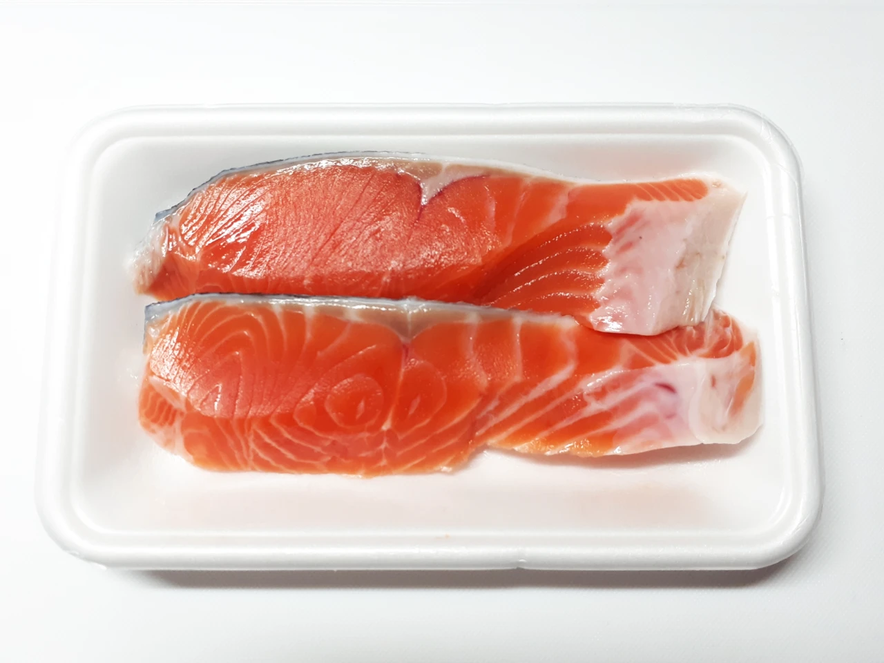 銀鮭是否能生食,關鍵不在「新鮮」而在產品是否符合生食條件;輪切帶骨適合鹽烤炙燒,菲力去骨方便嫩煎與料理,若製作刺身則須確認產品標示為生食用途並符合相關冷凍與食安要求。